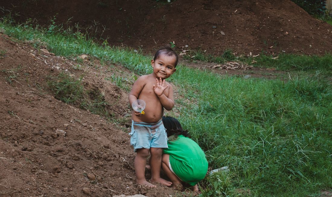 little Marquesan boy and girl playing in dirt