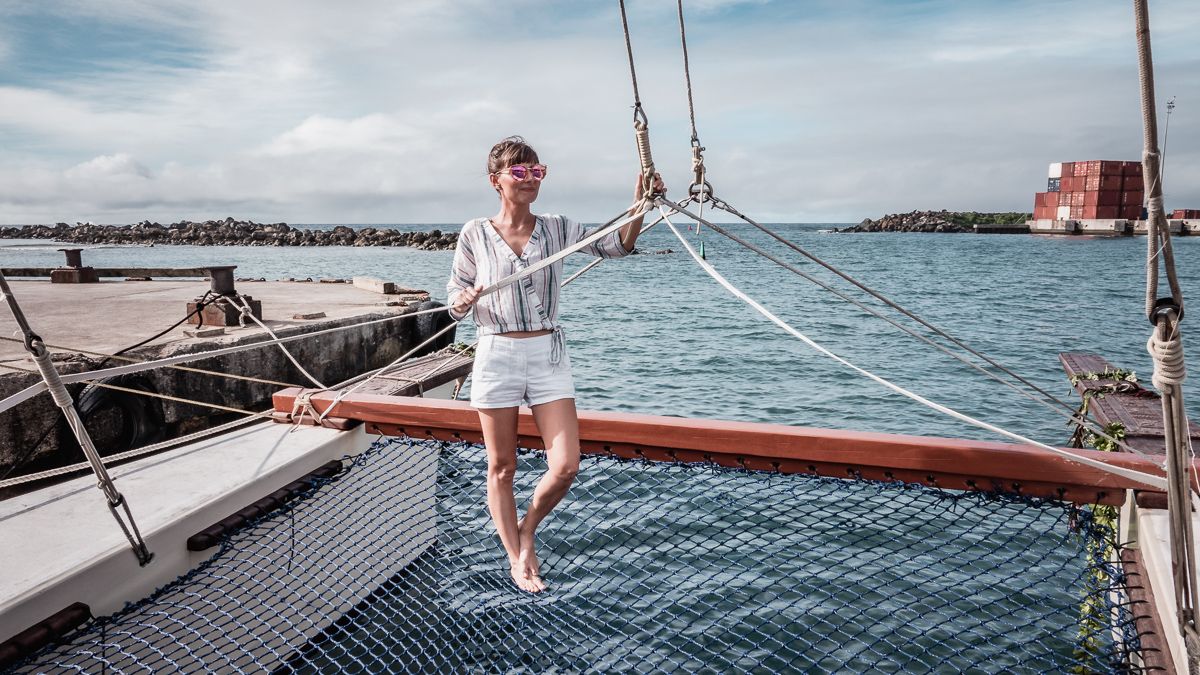 Nikki Wynn on the bow of traditional polynesian sailing vessel in cook islands south pacific