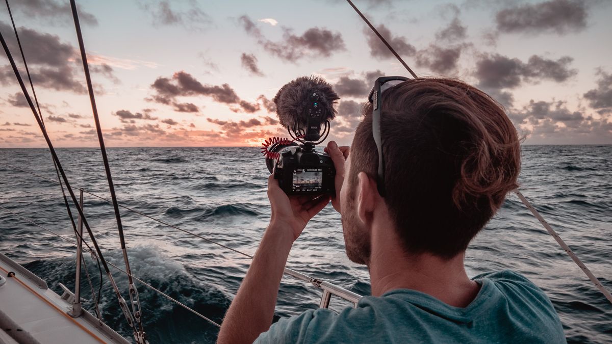 jason wynn capturing photos and video of a sunset at sea while sailing aboard catamaran curiosity 
