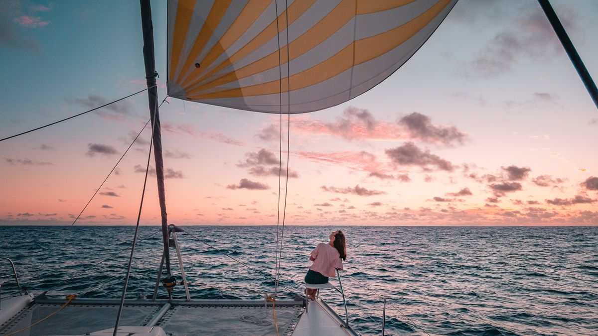 nikki wynn enjoying a beautiful downwind sunset sail aboard sailing catamaran curiosity