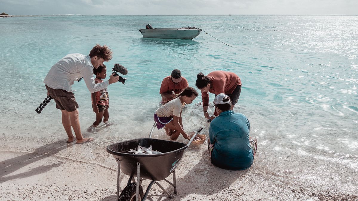 jason wynn capturing natives cleaning fish on palmerston island, cook islands