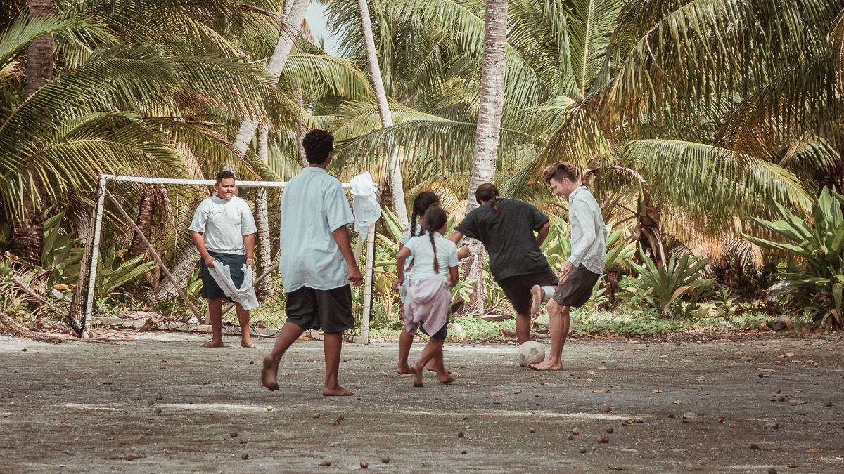 kids playing soccer in palmerston island, cook islands