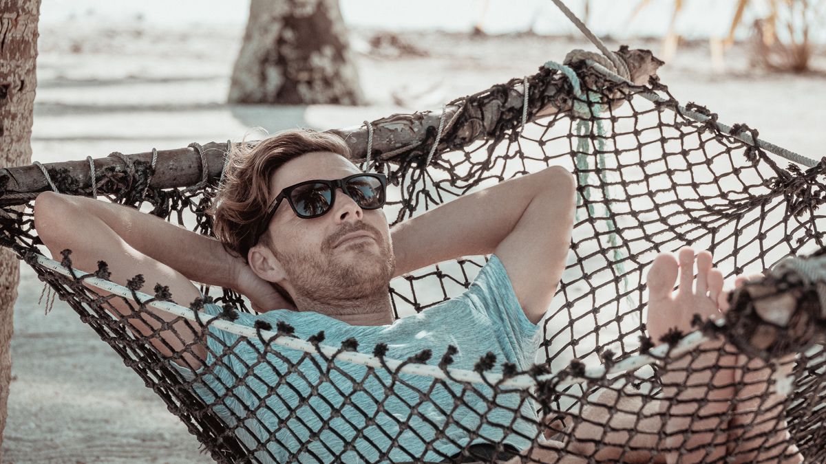 jason wynn relaxing in hammock on palmerston island, cook islands